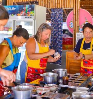 skupina lidí v kuchyni připravujících jídlo