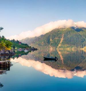 一艘船漂浮在有山的河上