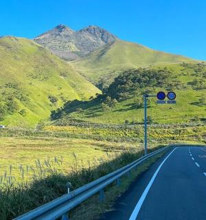 a traffic light on the side of a road with mountains