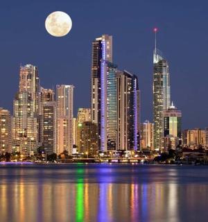 a city skyline at night with a full moon