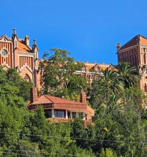 ein großes Gebäude auf einem Hügel mit Bäumen