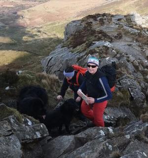 两个人和两只狗站在山上