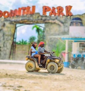 two people riding a toy quad bike in a toy park