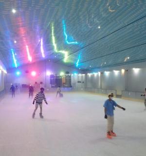 a group of people skating on an indoor rink