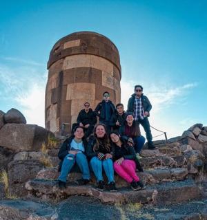 一群人坐在塔前的台阶上