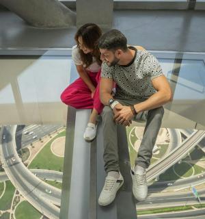 一男一女坐在玻璃塔顶上