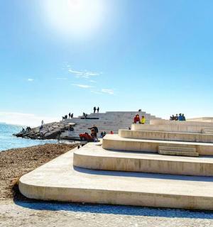 一群人坐在海边的台阶上