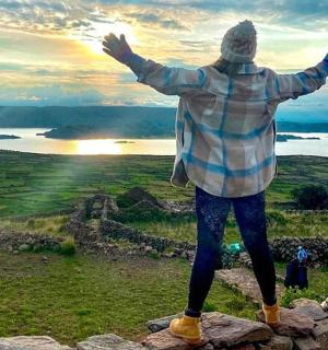 a person standing on top of a mountain with their arms outstretched
