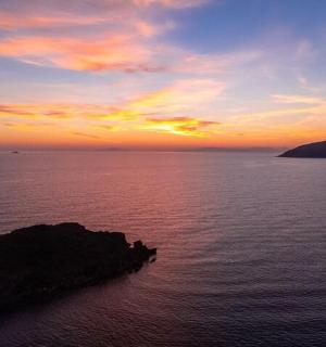 Západ slunce nad oceánem s kamenem ve vodě