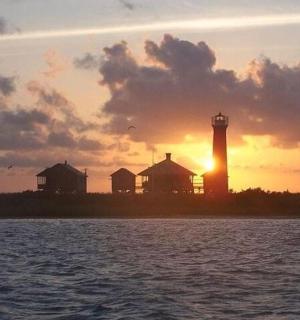 maják při západu slunce vedle vodní plochy