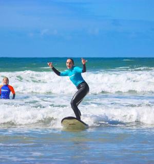 一名女子站在海中的冲浪板上