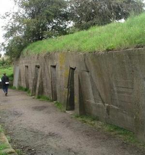 一名男子沿着墙边的土路行走