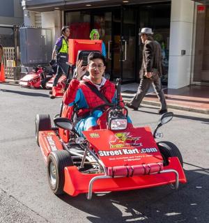 一个人在街上骑着一辆红色玩具车