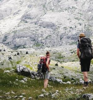 deux personnes avec des sacs à dos marchant sur une montagne