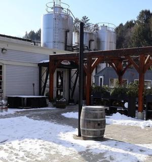 a yield sign in front of a building with barrels