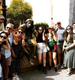 um grupo de pessoas em pé em frente a uma estátua