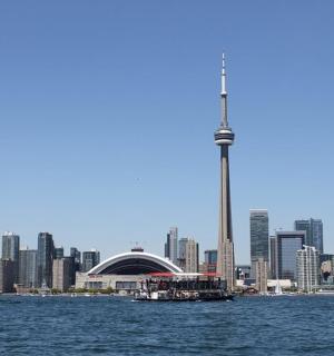 a boat in the water in front of a city