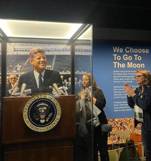 žena stojící u pódia před projevem