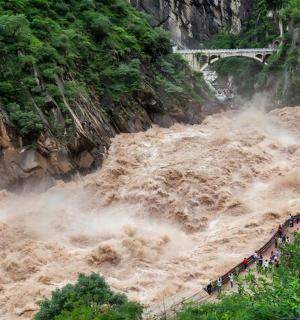 一群人站在汹涌的河流前