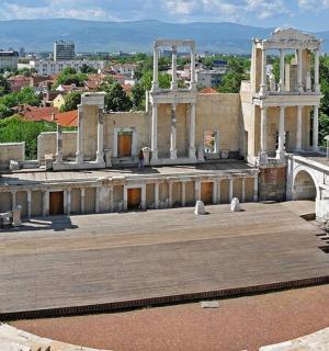 a large amphitheater with a city in the background