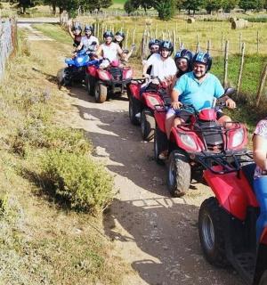 skupina lidí jedoucích na čtyřkolkách po nezpevněné cestě