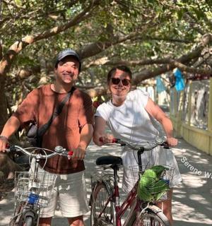 两名男子骑着自行车站在桥上