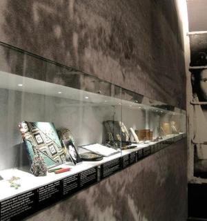 a room with a shelf with pictures on the wall