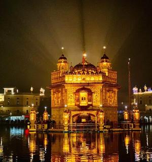 a large building sitting in the water at night