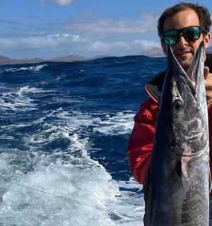 船上抱着鱼的男人