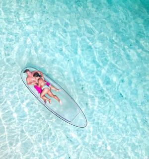 一名女子躺在水中的冲浪板上