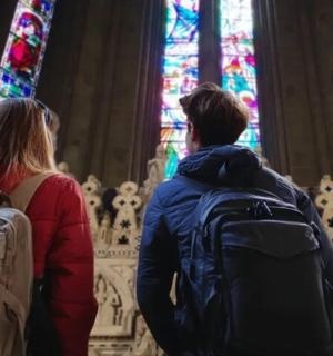dva lidé stojící v katedrále a dívající se na vitrážová okna
