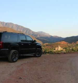 ein schwarzer SUV, der am Rand einer unbefestigten Straße geparkt ist