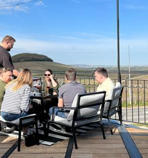 一群人坐在露台的一张桌子旁