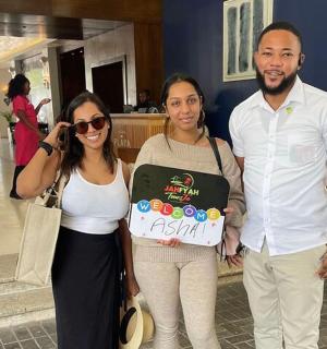 a group of people posing for a picture with a cake