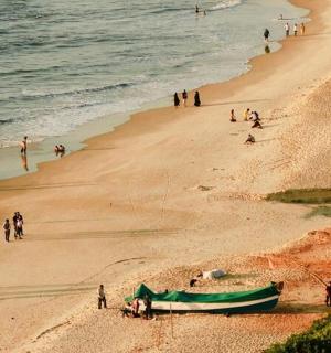 skupina lidí na pláži s lodí