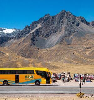 一辆黄色巴士沿着山附近的道路行驶
