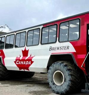 Červenobílý nákladní vůz zaparkovaný před horou