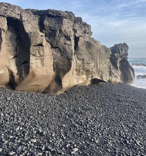 a beach with rocks and the ocean next to the ocean