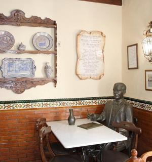 uma estátua de um homem sentado à mesa em uma sala