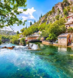 řeka s modrou vodou, budovami a horou