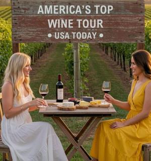 two women sitting at a table with wine glasses