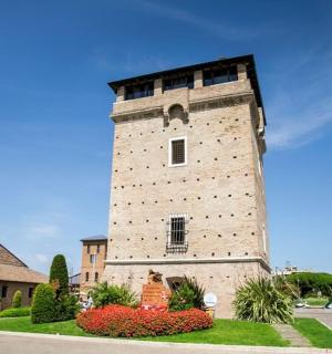 a tall brick tower with flowers in front of a building