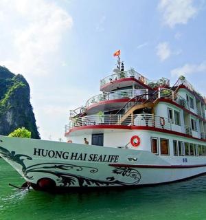 a large boat in the water next to a mountain