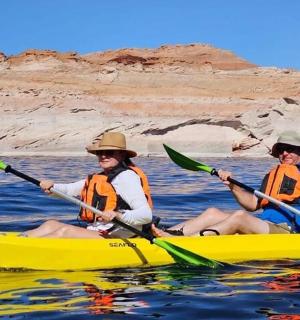 two people in a yellow kayak in the water