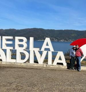 两个撑着伞的人站在标志牌前