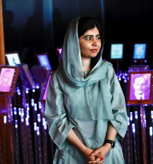 一位戴着头巾的女士站在展品前