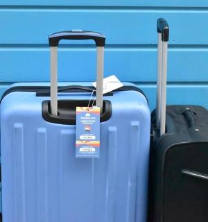 two pieces of luggage sitting next to a blue wall