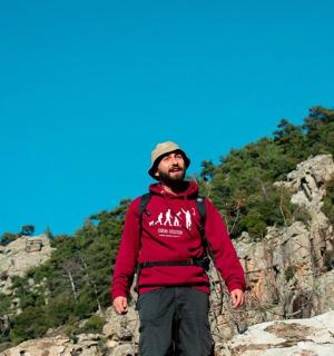 muž stojící na vrcholu skalnaté hory