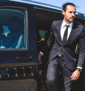 一名西装革履的男子从一辆货车上走下来