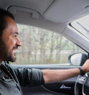 一名男子一边开车一边看着窗外